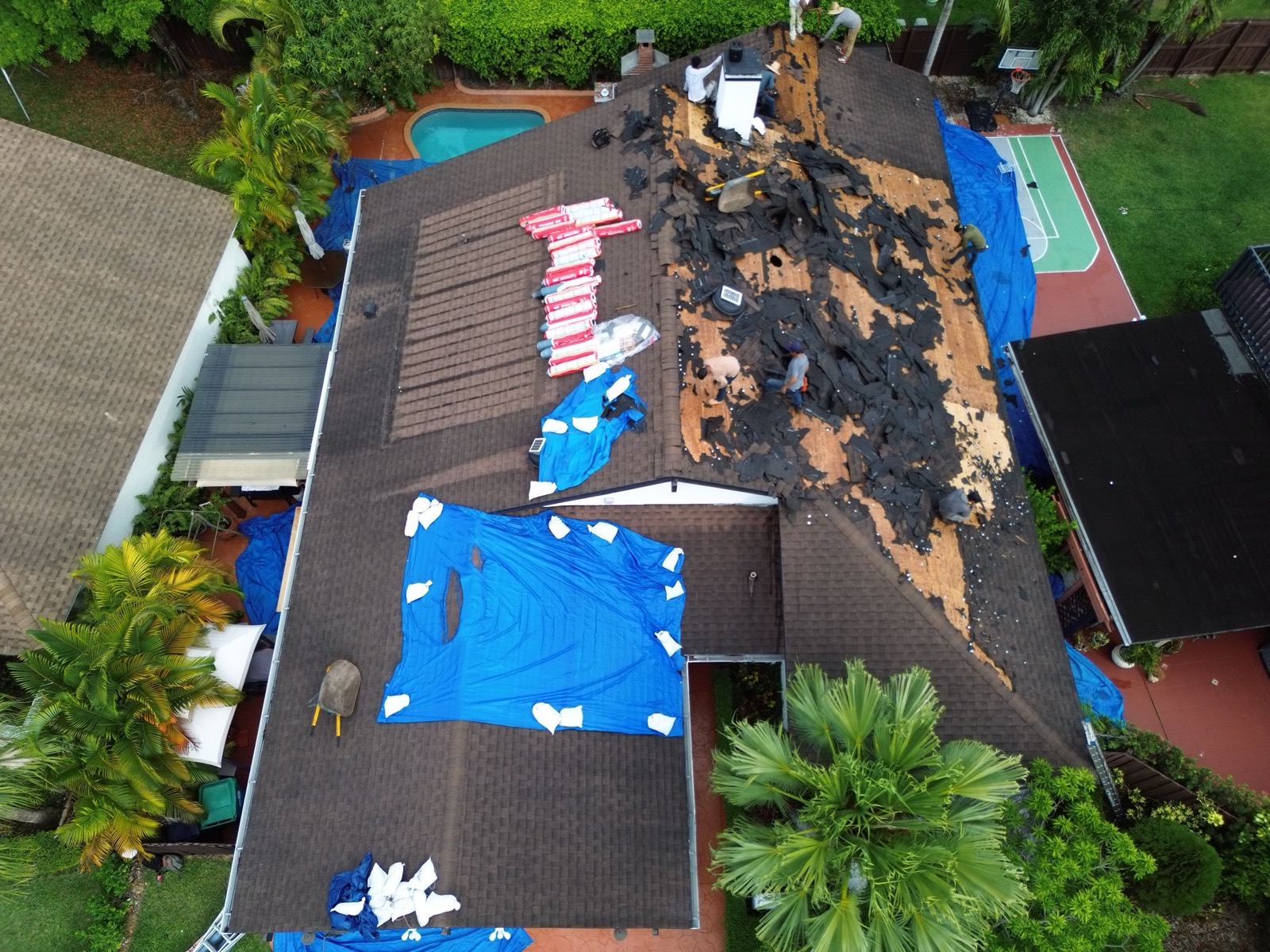 Old asphalt roof being stripped before replacement in Southwest Miami-Dade